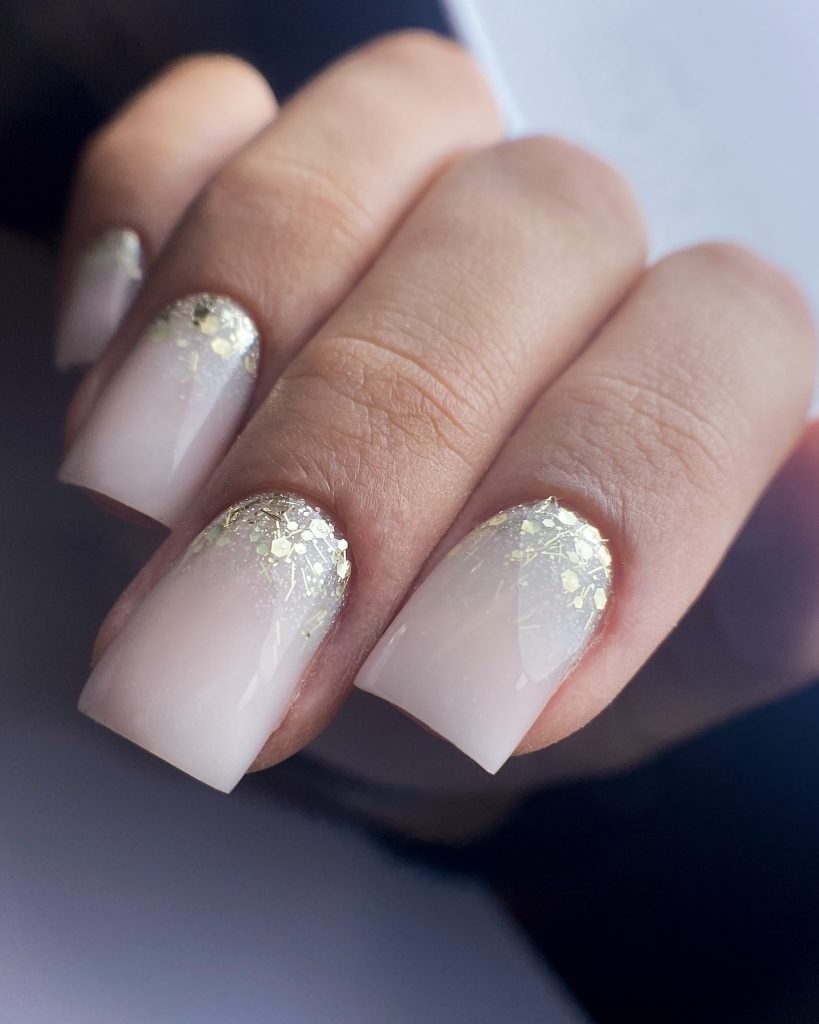 Elegant nails with white and gold glitter design, perfect for a chic manicure style.