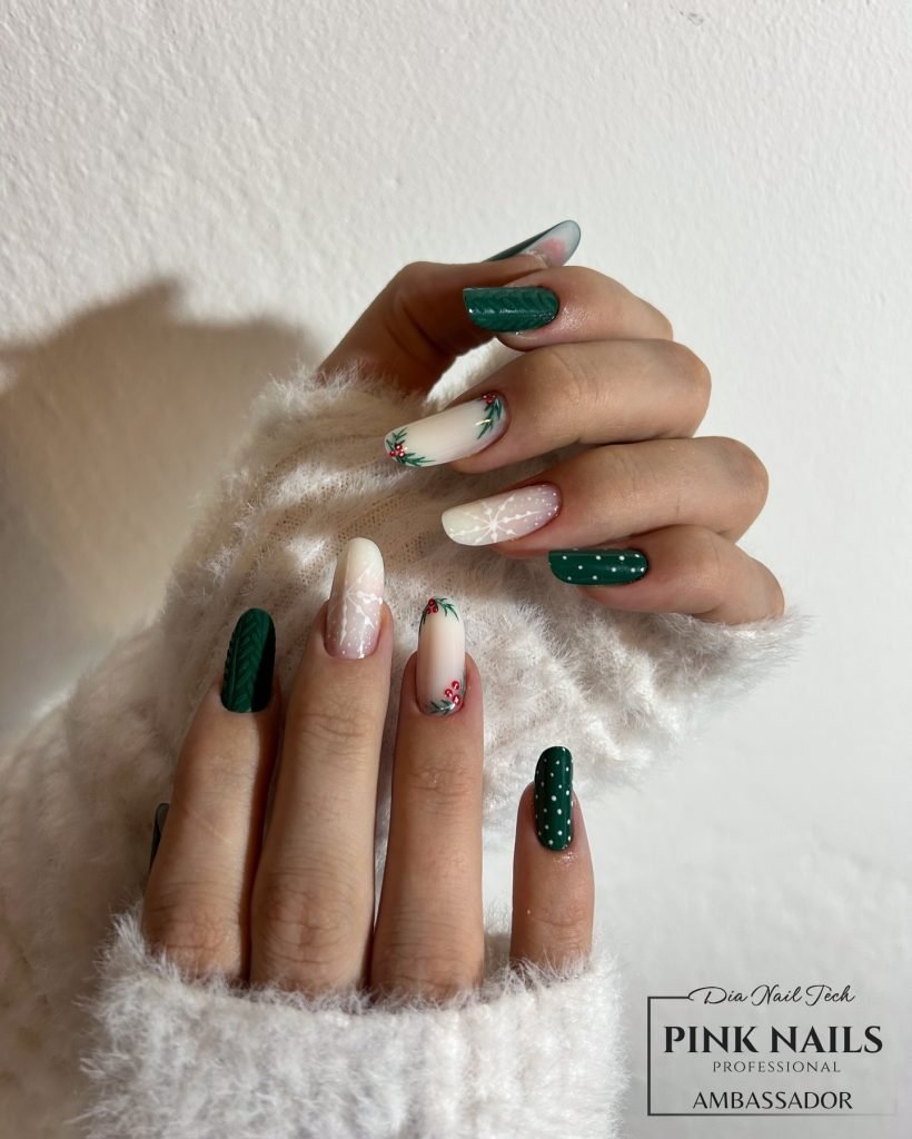 Festive green and white nails with floral and polka dot designs, perfect for a holiday look. Cozy sweater background.
