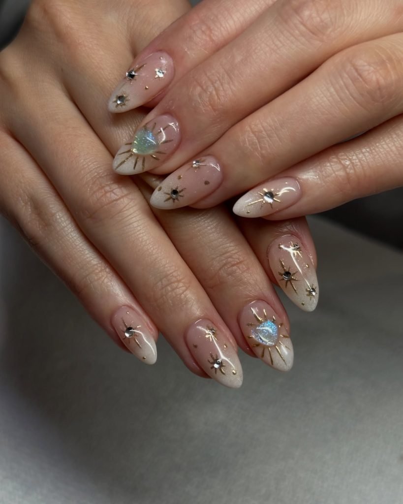 Elegant nail art with gold and silver star designs on almond-shaped nails.