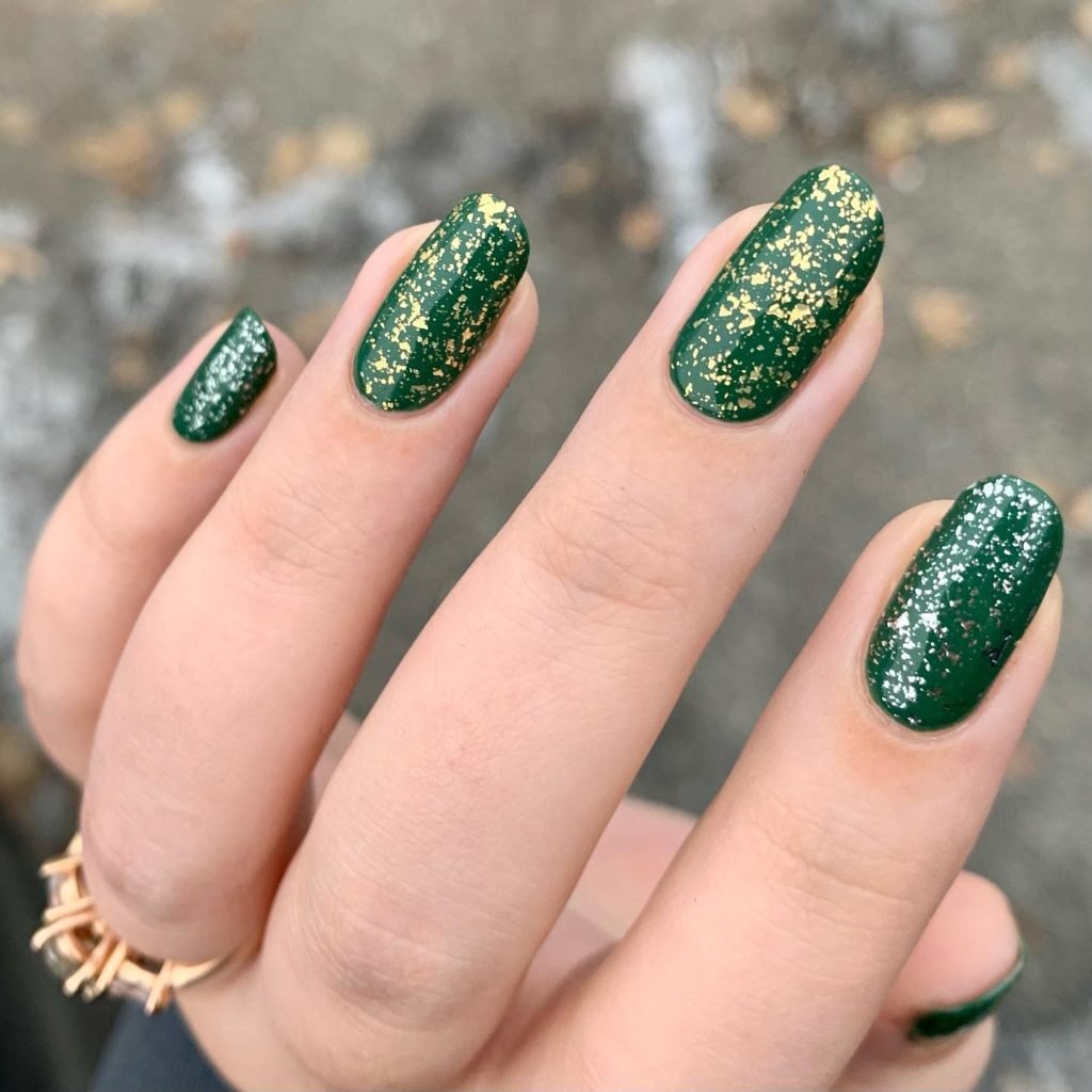 Green nails with gold glitter accents, showcasing a chic manicure for holiday or everyday glam.