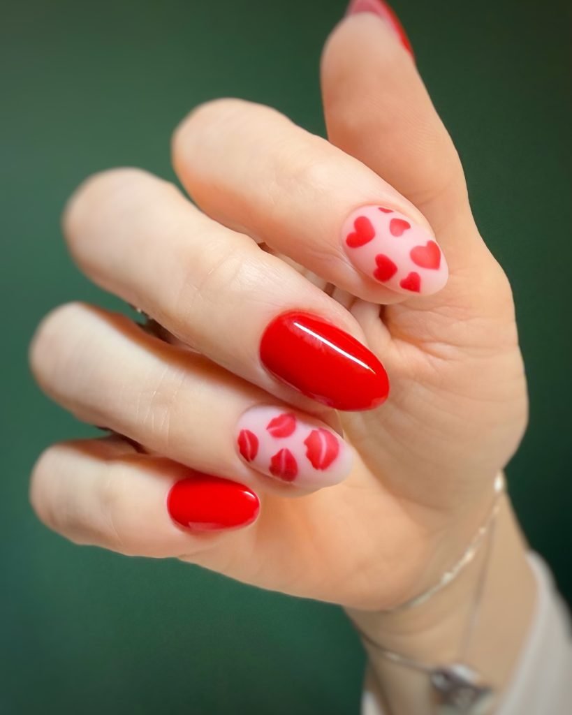 Red and pink heart nail art design on manicured nails, perfect for a romantic, stylish look.