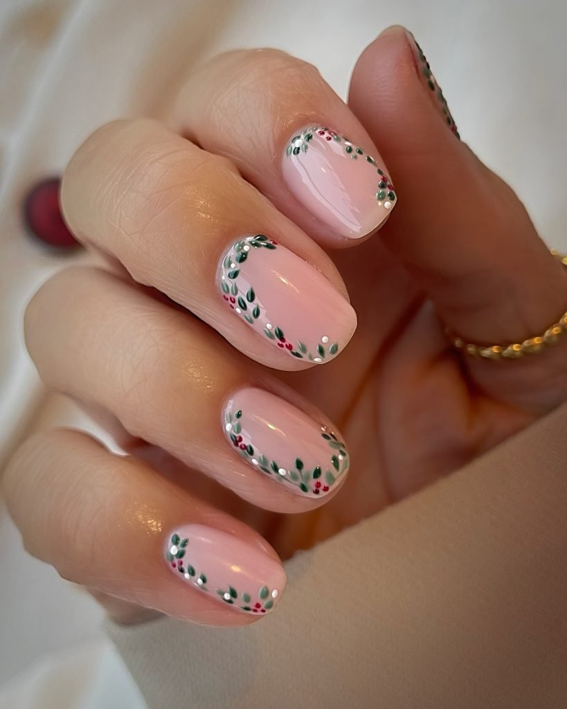 Delicate pink nails with intricate floral design and green leaves for a stylish and elegant look.