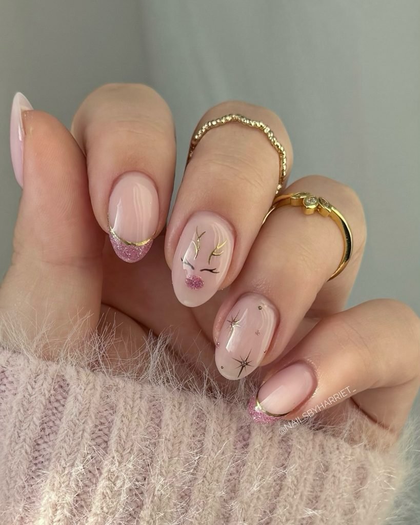 Elegant pink manicure with gold accents and star designs, perfect for a stylish and chic winter nail art look.