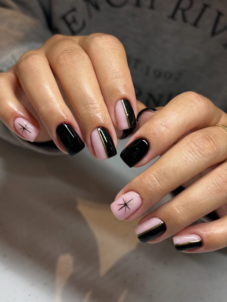 Stylish pink and black manicure with star design on fingernails, showcasing elegant nail art trends.