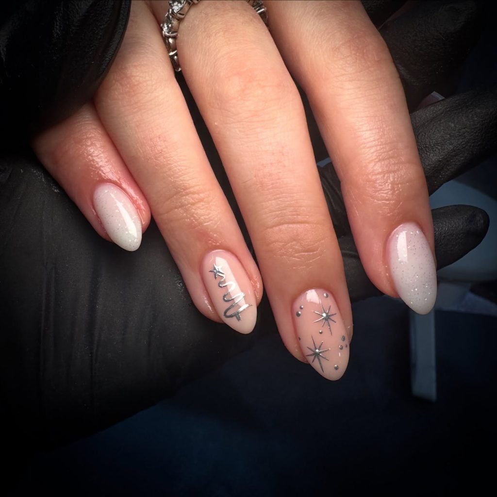 Elegant manicure with silver and white star designs on long, almond-shaped nails. Perfect for stylish nail art inspiration.