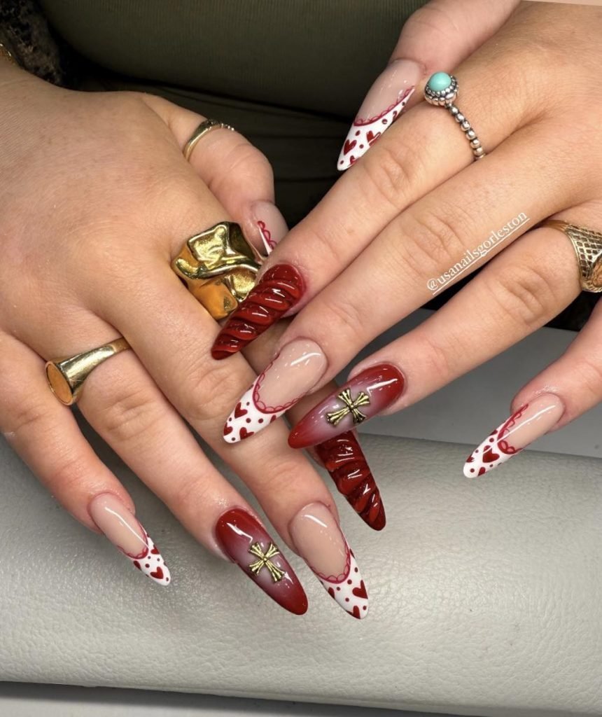 Red and white Valentine's Day nail art with heart and bow designs, showcasing a chic and stylish manicure.