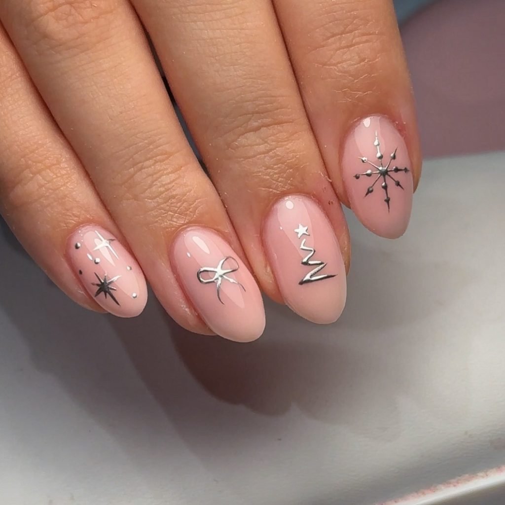 Pink manicure with silver designs: bows, stars, snowflakes, and tree. Festive nail art on almond-shaped nails.