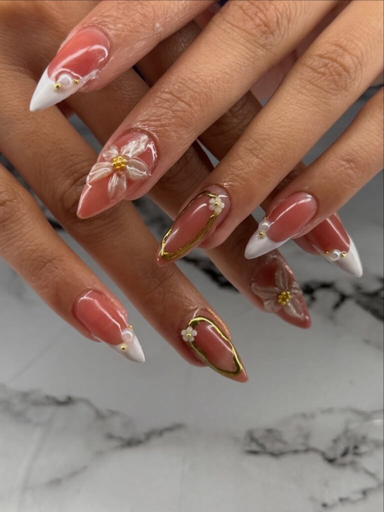 Elegant almond-shaped nails with floral accents and white tips, perfect nail art inspiration for a chic look.