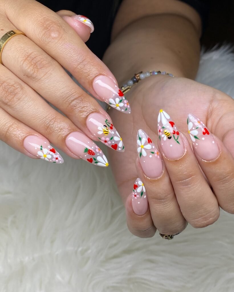 Colorful floral and bee nail art on long almond-shaped nails, perfect for spring or summer designs.
