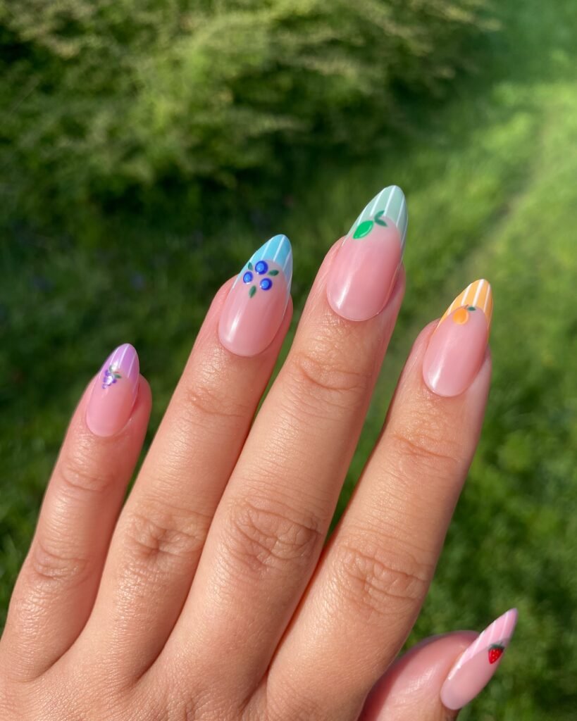 Colorful floral nail art with pink base on natural nails in sunlight.