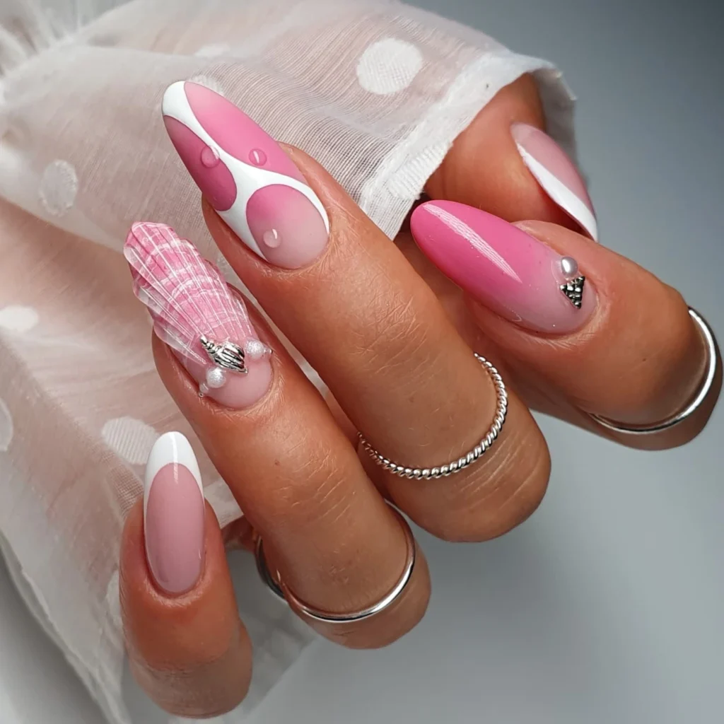 Stylish pink and white nail art with geometric patterns and seashell design, showcasing elegant, trendy manicure rings.