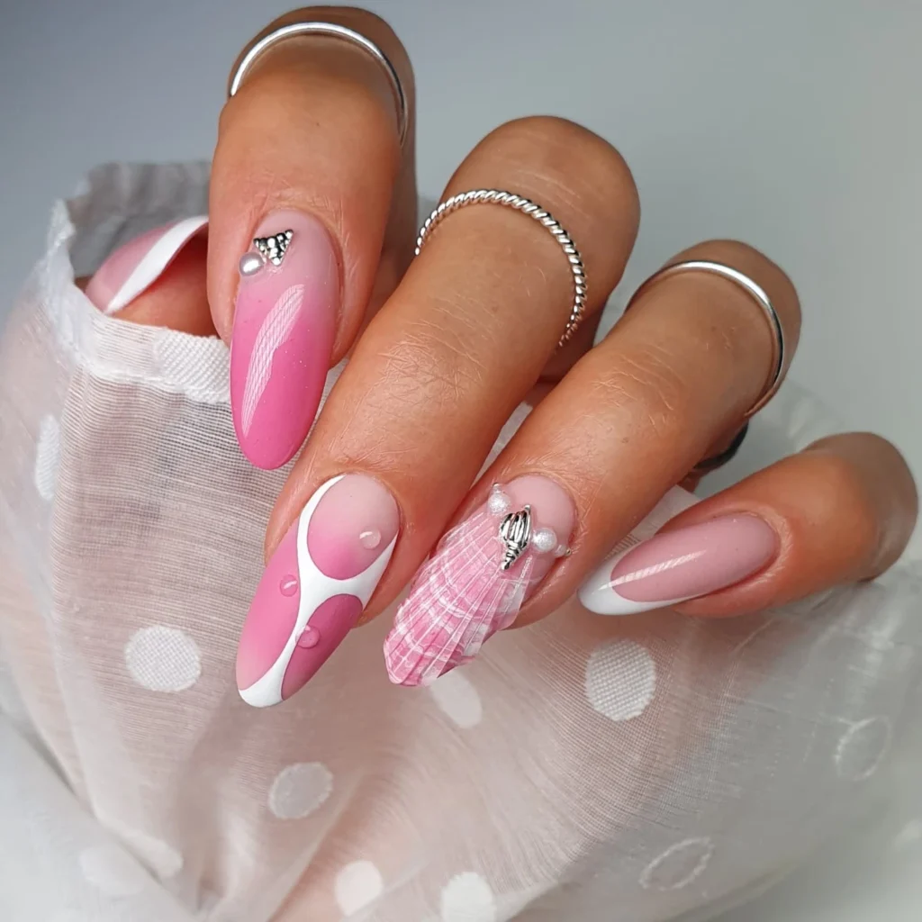 Close-up of stylish pink and white nail art with geometric designs and elegant embellishments.