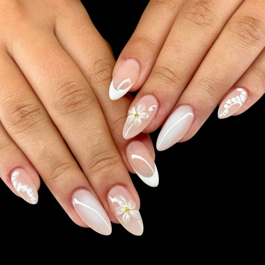 Elegant white manicure with floral accents on almond-shaped nails. Perfect for weddings or special occasions.