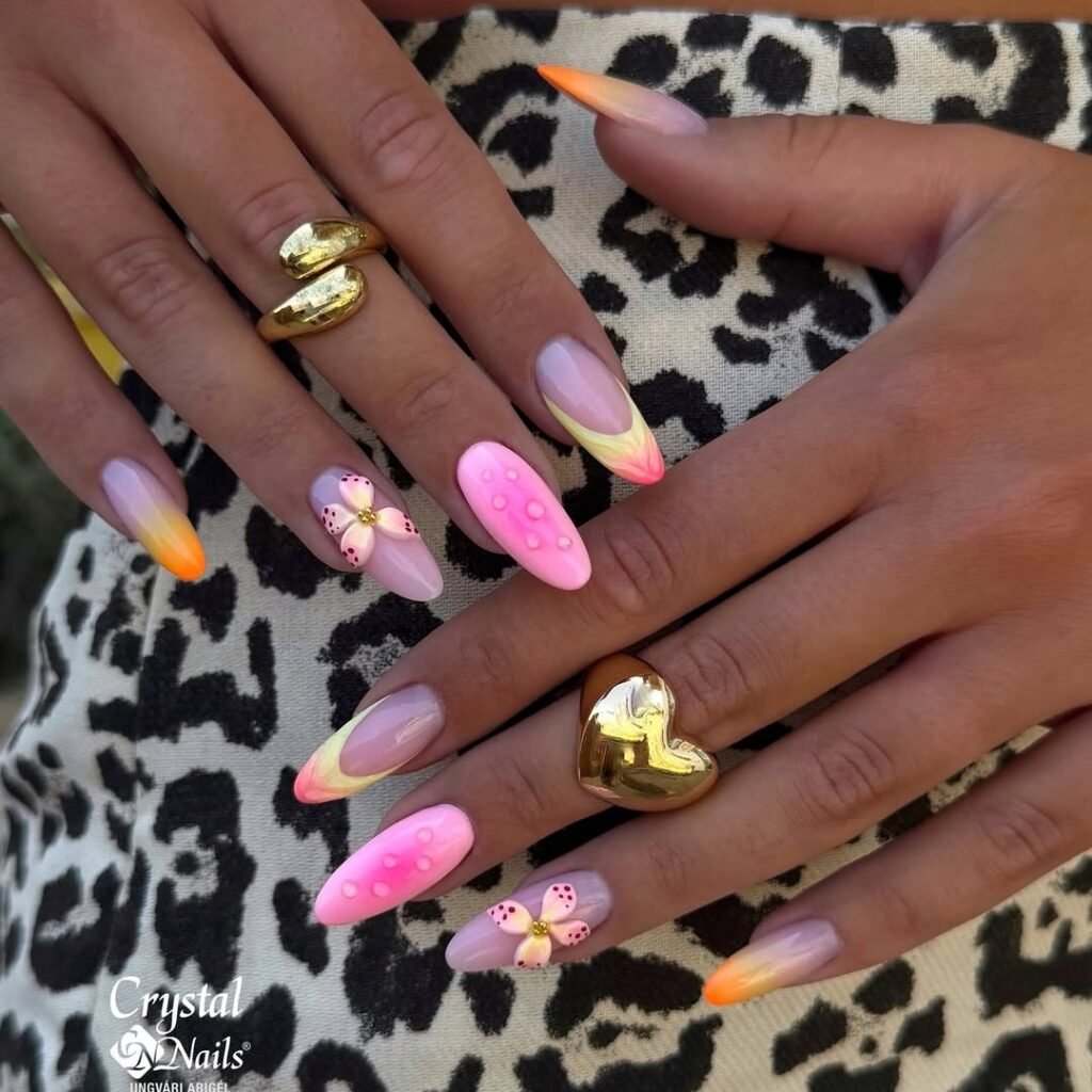 Colorful floral and gradient nail art with gold rings over a leopard print fabric background.