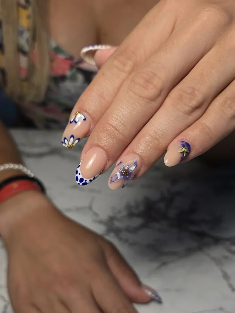 Elegant floral nail art with daisy and lavender designs on a marble background.