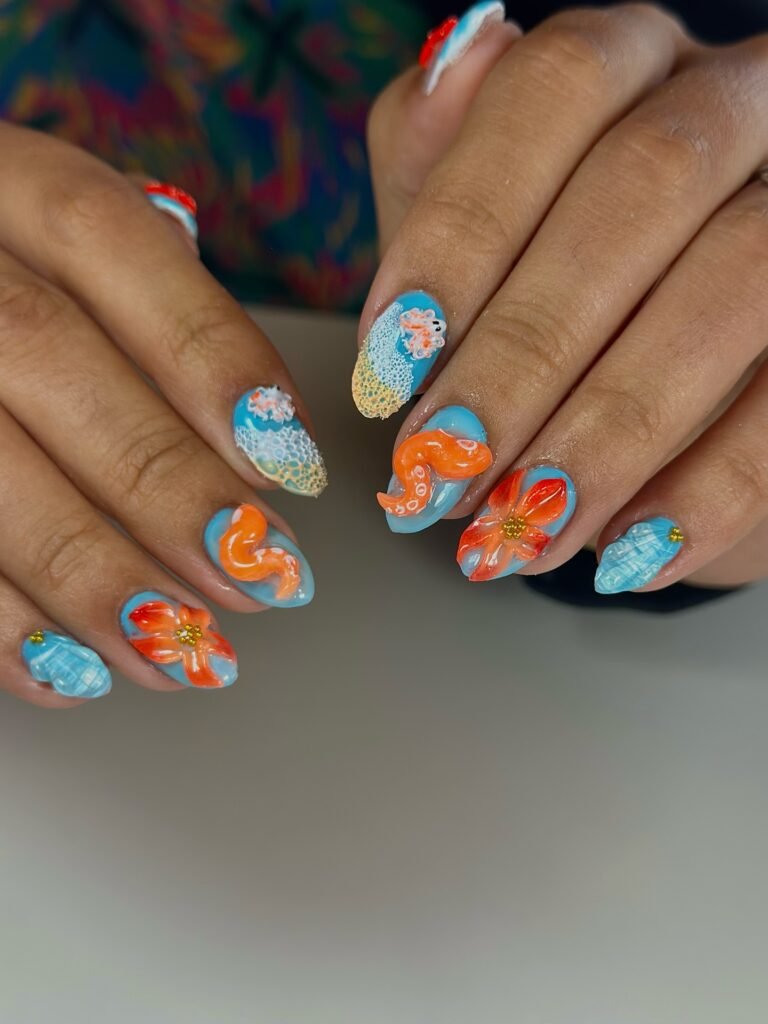 Bright summer-themed 3D nail art with blue, orange, and floral designs.