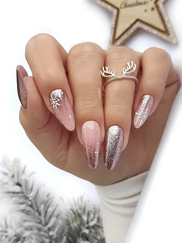 Elegant holiday-themed nails with glitter and snowflake designs, decorated with a stylish reindeer antler ring.