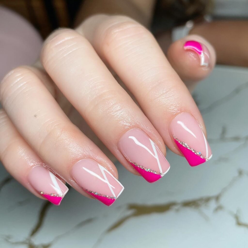 Pink and white geometric nail art design on a hand with a marble background.