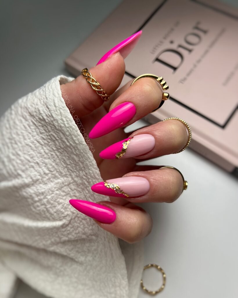 Pink and nude manicured nails with gold details and rings, styled over a Dior book background.