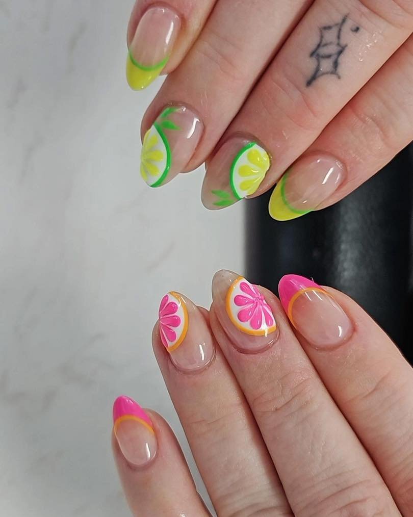 Colorful citrus-themed nail art with vibrant pink, yellow, and green designs. Fresh, fruity manicure style.