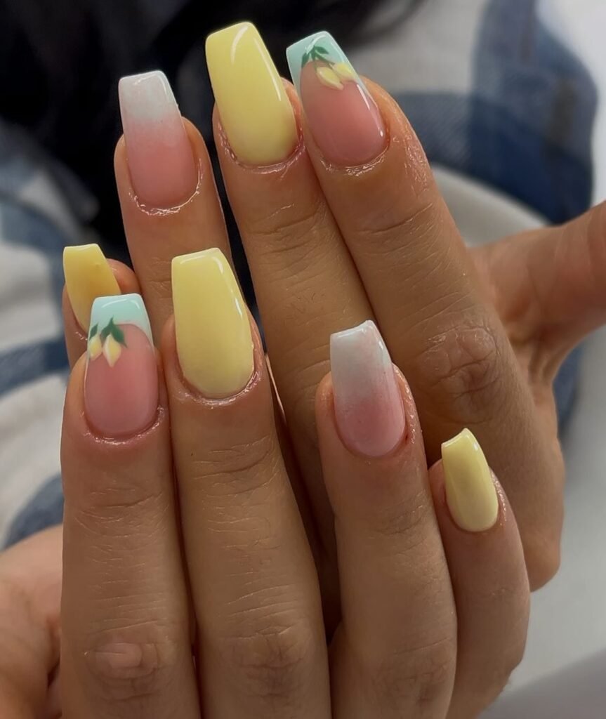 Yellow and pastel ombre nails with floral accents, showcasing trendy square acrylic nail design.