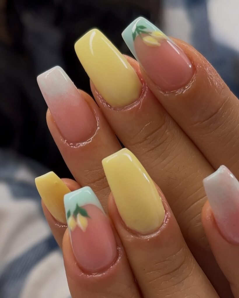 Colorful acrylic nails with pastel yellow and floral accents, showcasing intricate spring-inspired nail art design.
