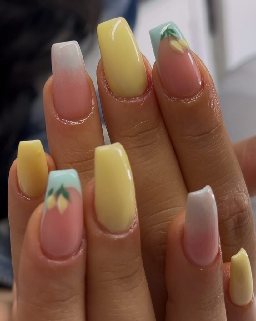 Colorful pastel nails with yellow accents and floral designs on square-shaped tips. Fashionable nail art close-up.