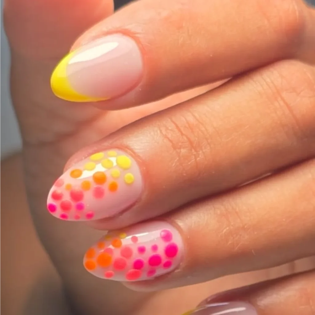 Colorful polka dot and yellow French tip nail art on a hand, showcasing a trendy and vibrant manicure design.