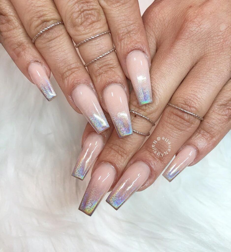 Holographic ombre coffin nails with silver rings on a white background, showcasing trendy manicure style.