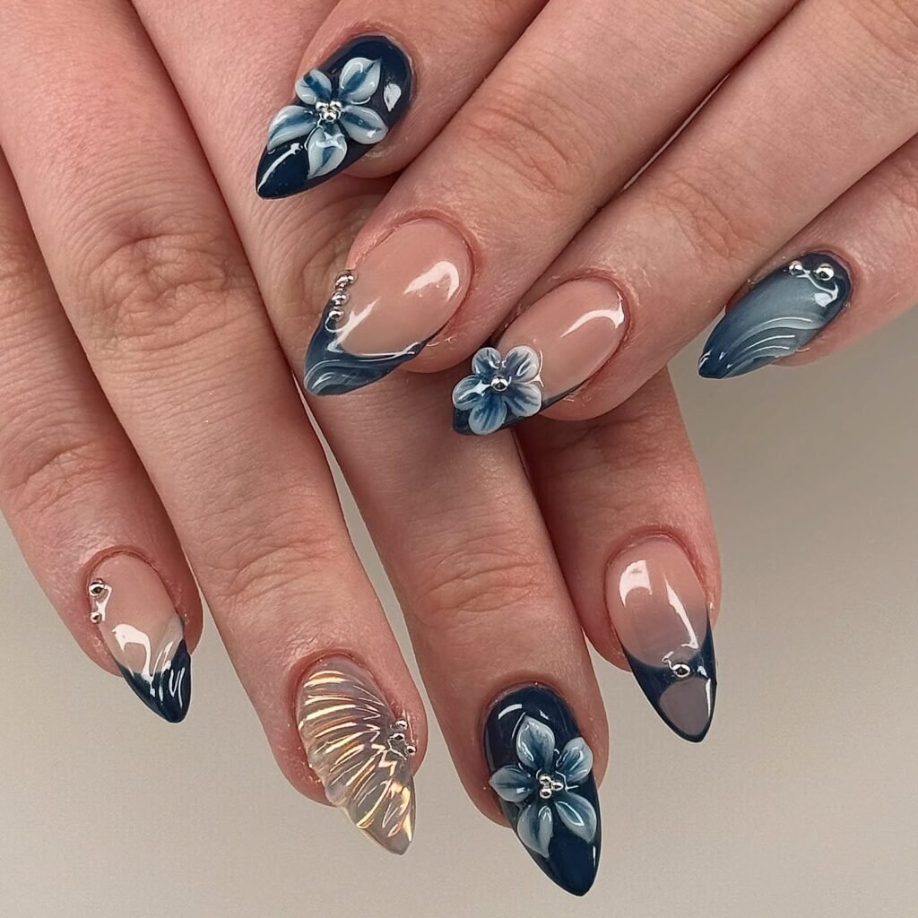 Elegant blue floral nail art design with 3D flowers and glossy finish on long pointed nails.
