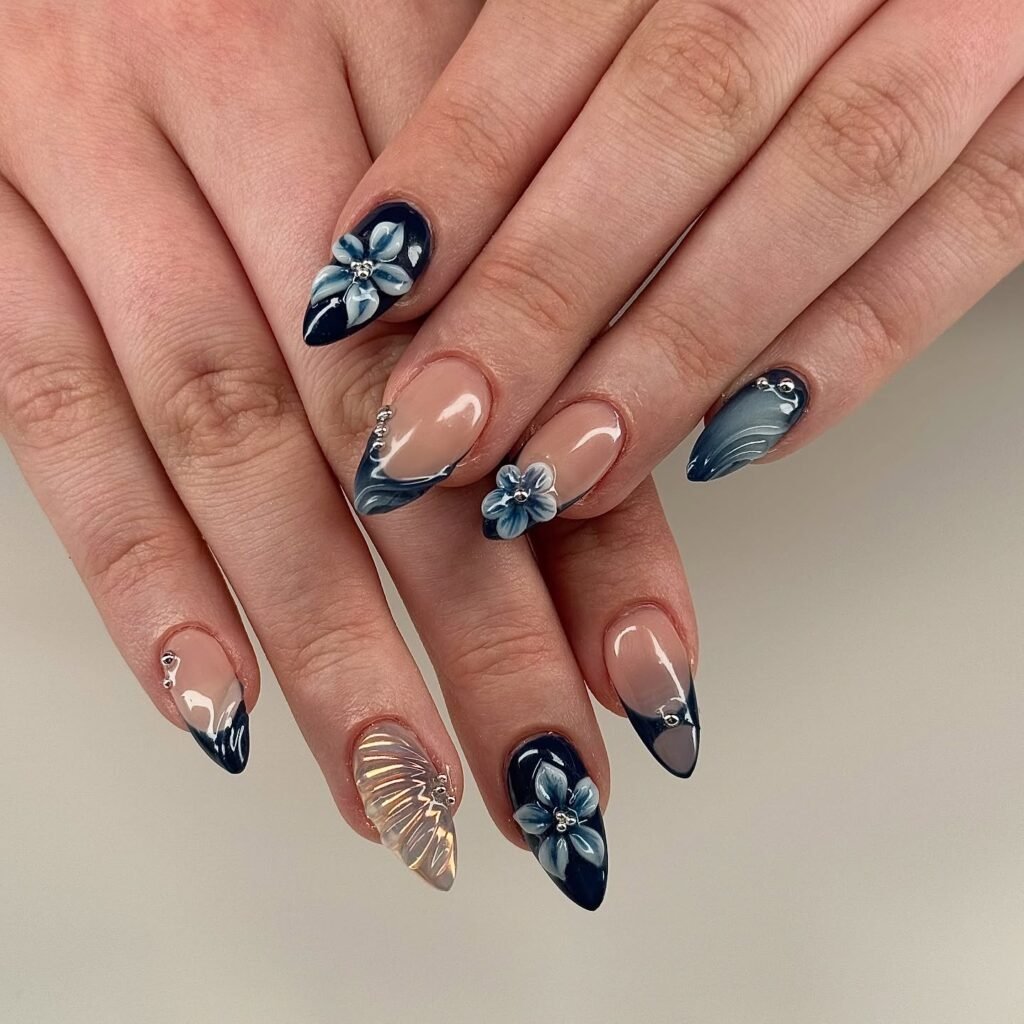 Elegant almond-shaped nails with blue floral and butterfly nail art design.