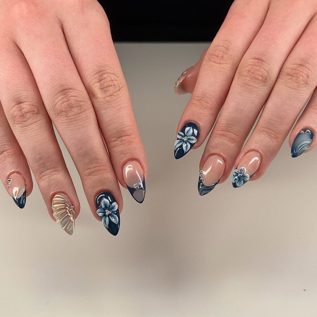 Blue floral nail art with 3D flowers and rhinestones on almond-shaped nails. Elegant and creative manicure design.