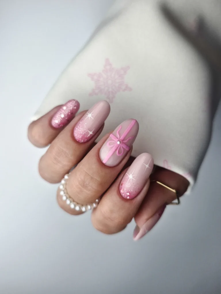 Pink and nude festive nail art with glitter, snowflake, and ribbon designs, perfect for a winter holiday look.