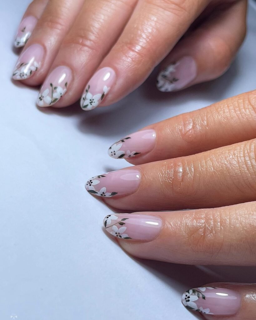 Elegant pink and white floral nail art with delicate blossom designs on a glossy manicure.