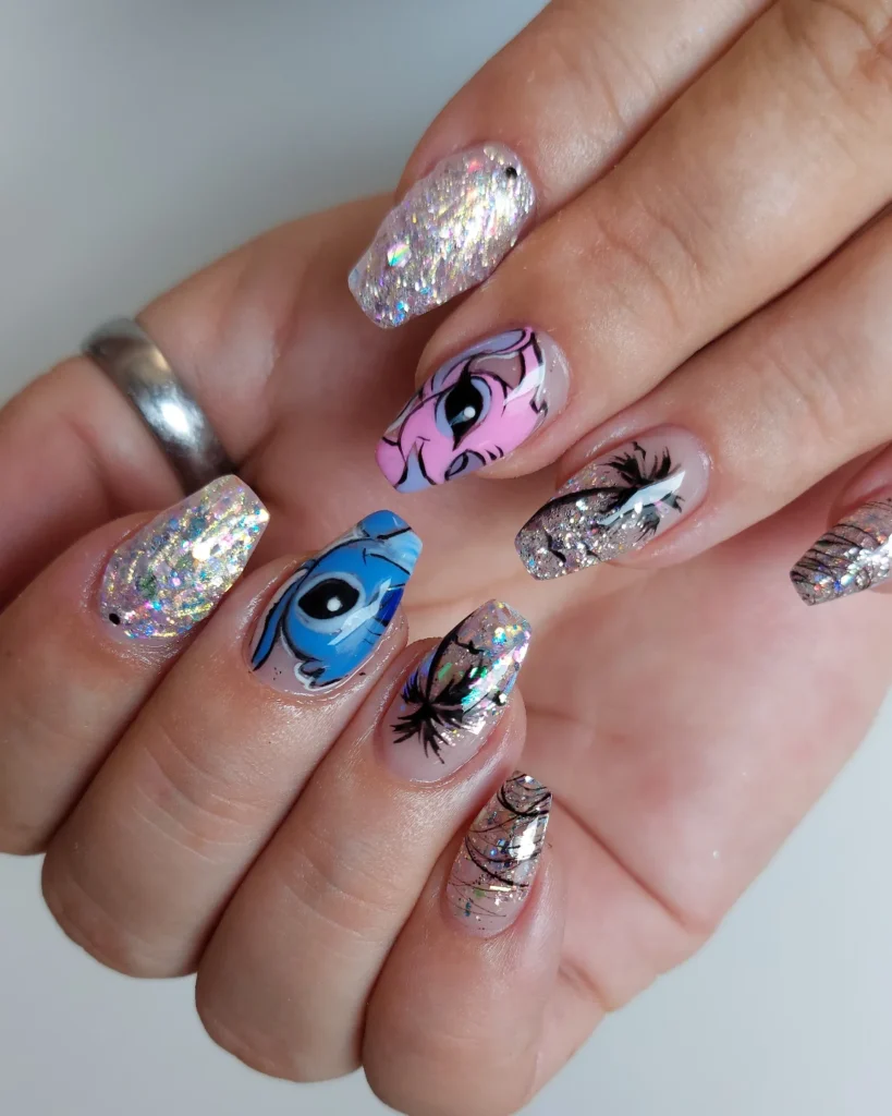 Colorful glitter and character nail art design on hand with silver ring.