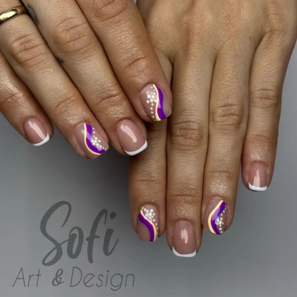 Stylish nail art with purple and white wave design, featuring pearl accents and French tips.