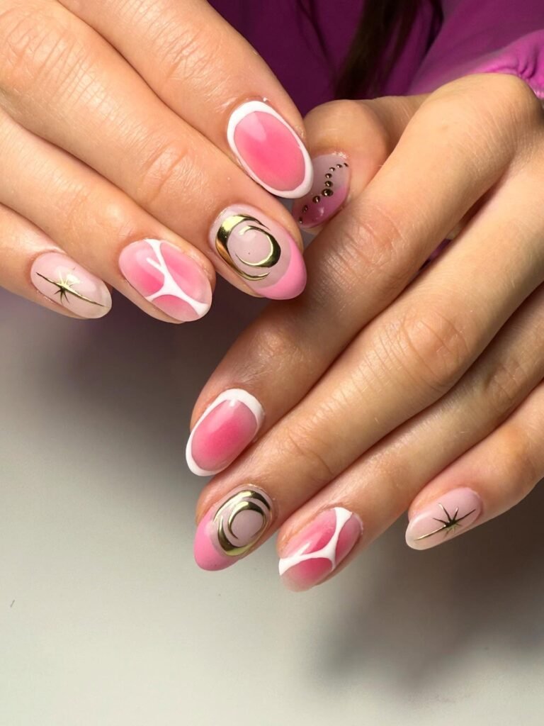 Pink and white abstract nail art design with gold accents on oval-shaped nails.
