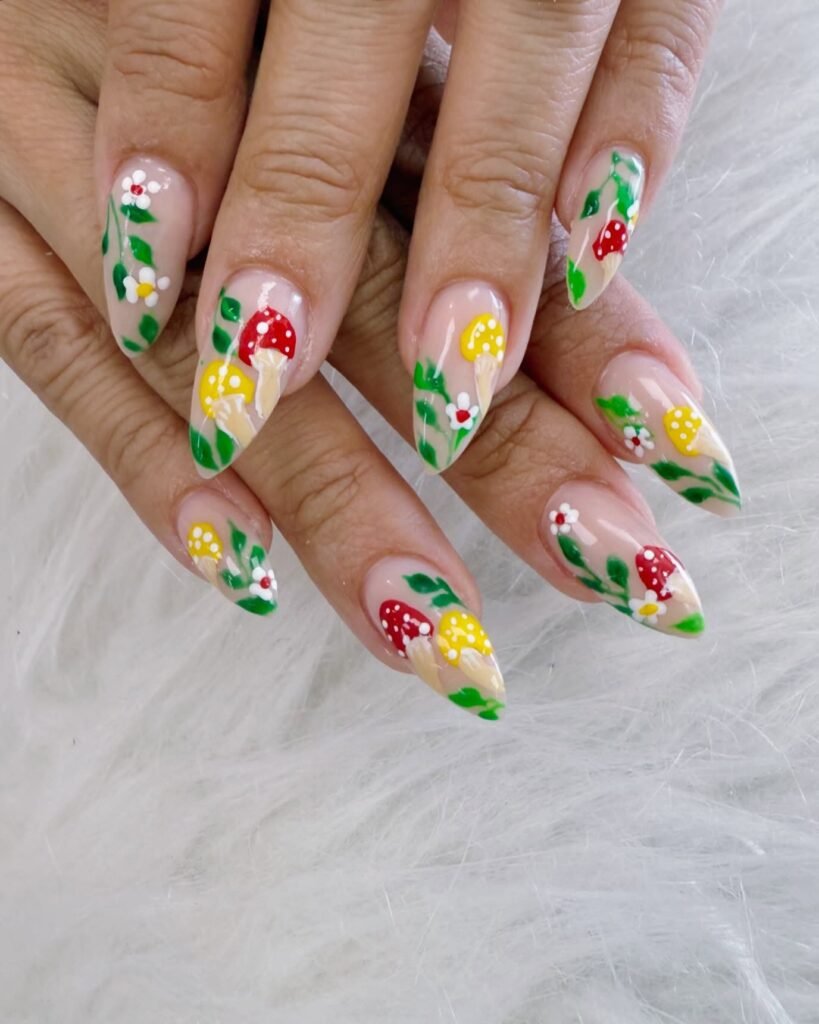 Colorful floral and mushroom nail art design on a person's hands, featuring red and yellow accents.