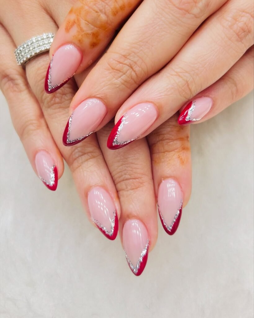 Stylish red and silver French tip nails with a sparkling diamond ring on hand.