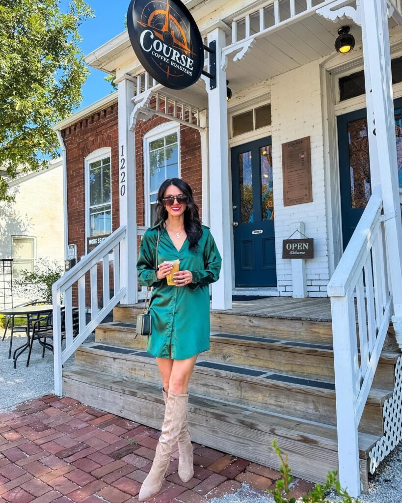 Woman in green dress enjoying coffee outside Course Coffee Roasters on a sunny day.