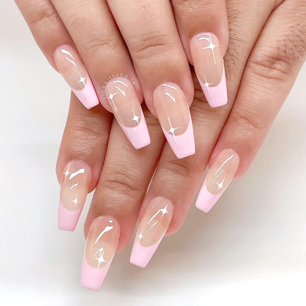 Pink ombre coffin nails with glossy finish and star accents, showcasing elegant manicure style.