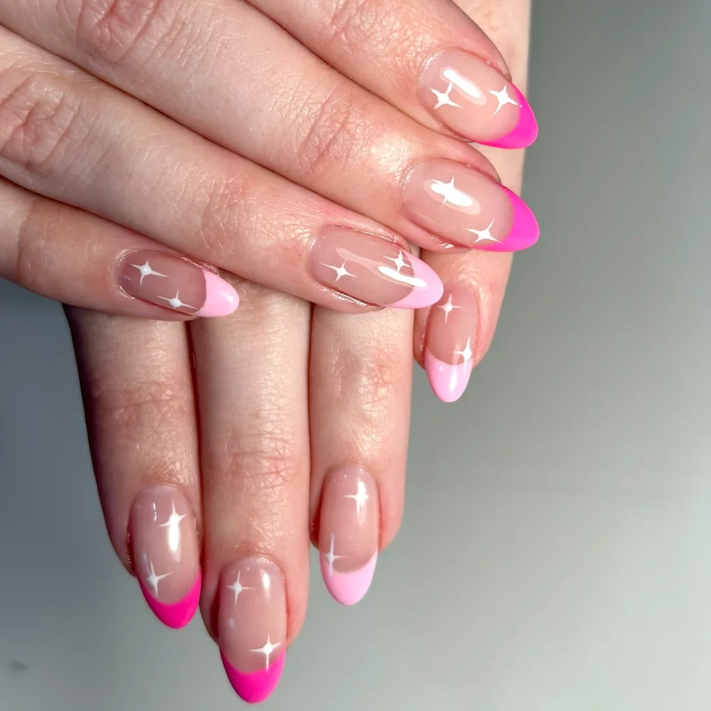 Pink and clear nails with star designs, showcasing trendy and elegant nail art for fashionable hands.