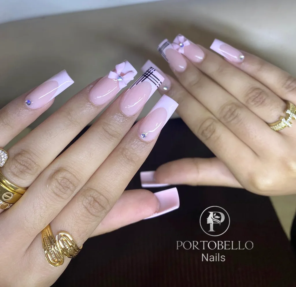 Elegant pink acrylic nails with flower and rhinestone accents, showcasing luxury nail design from Portobello Nails.